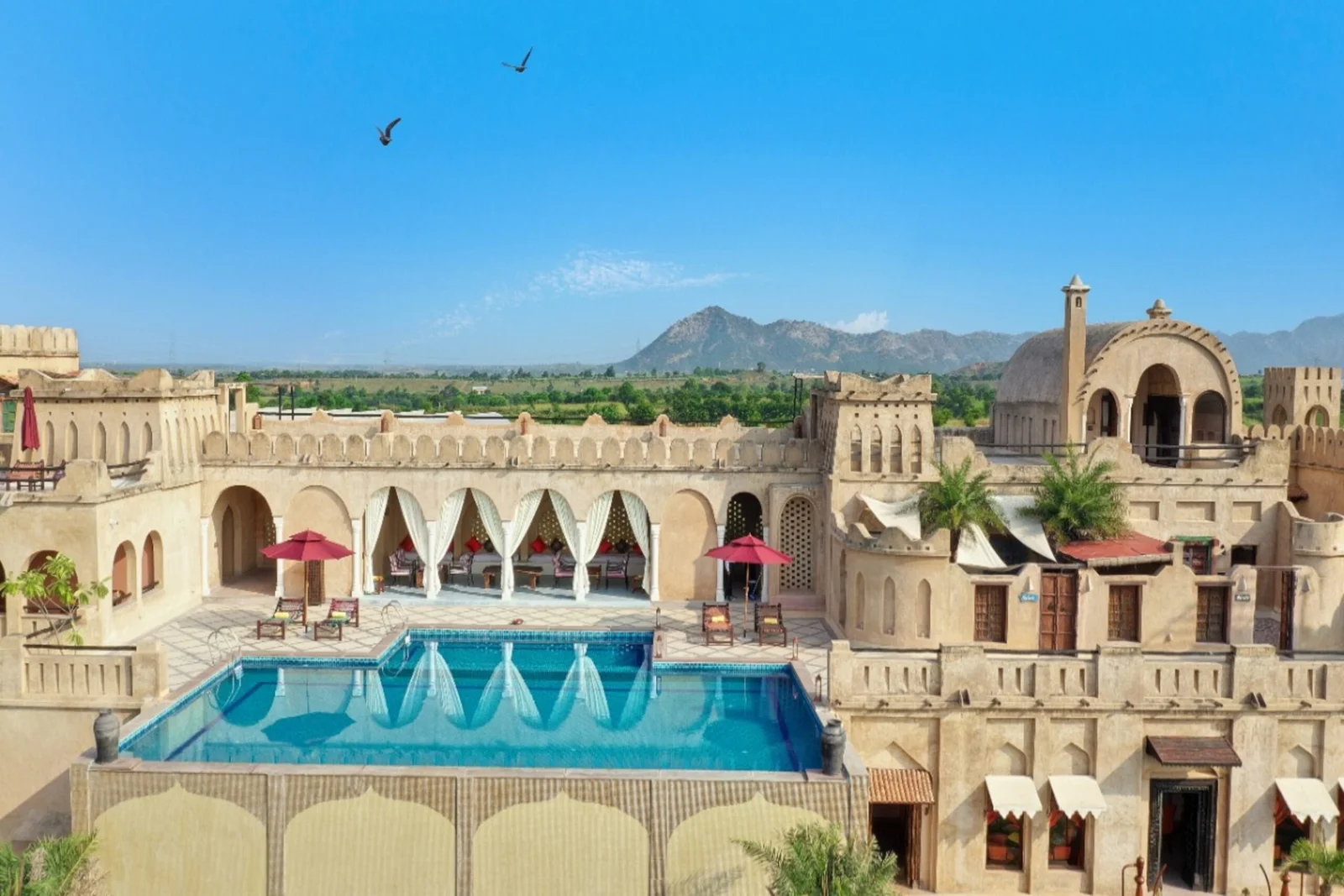 <h3>MayaGarh, Pushkar</h3>
Located in a big 17-acre desert oasis mere minutes from Pushkar, Mayagarh takes guests into a world reminding one of UAE’s tropical-modern architecture—sensational domes, arches, and ornate interiors paying homage to Middle Eastern tradition. Every one of the 10 spacious Arabian villas with their own bathrooms is a luxury hideaway.